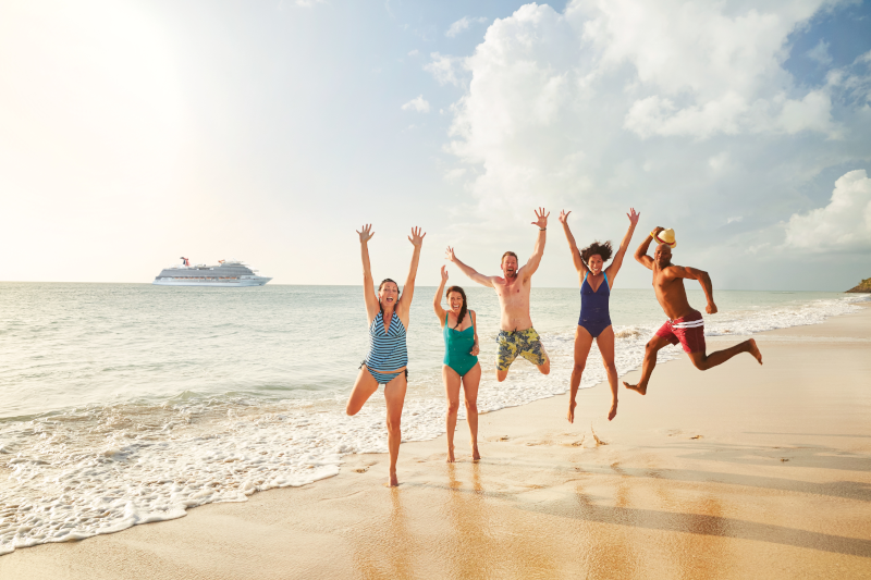 Carnival Guests jumping for joy with ship in the background