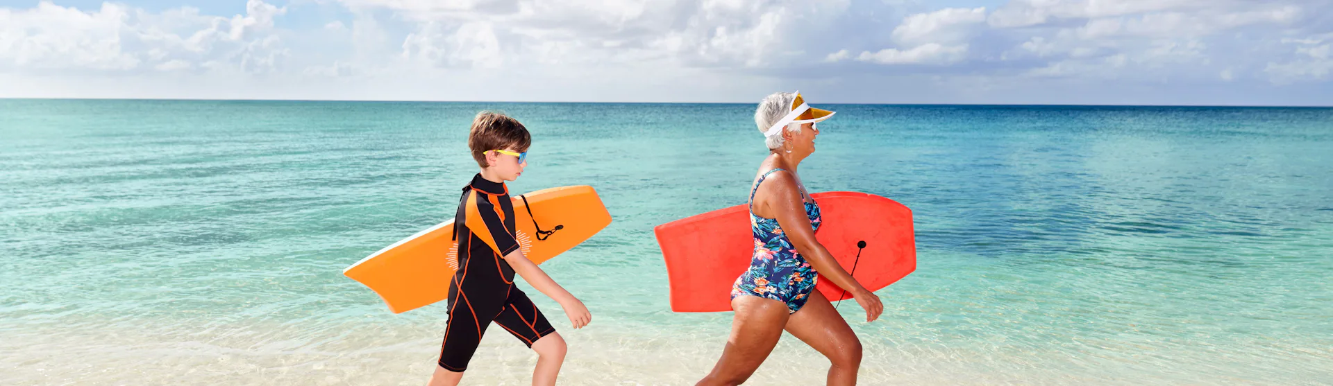 Grandma and Grandson walking in water with boogie boards